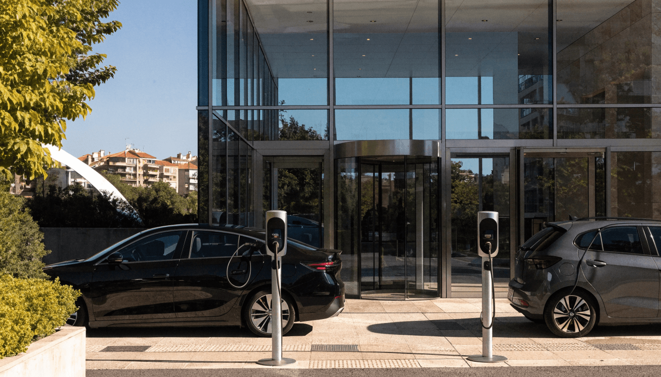 Puntos de recarga en la entrada de un hotel u oficina con dos coches eléctricos cargando
