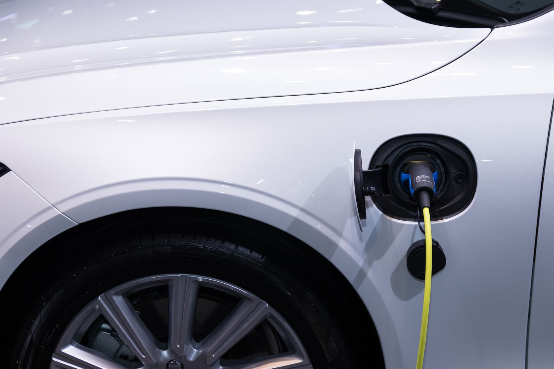 Coche eléctrico cargando con el cable conectado al punto de recarga