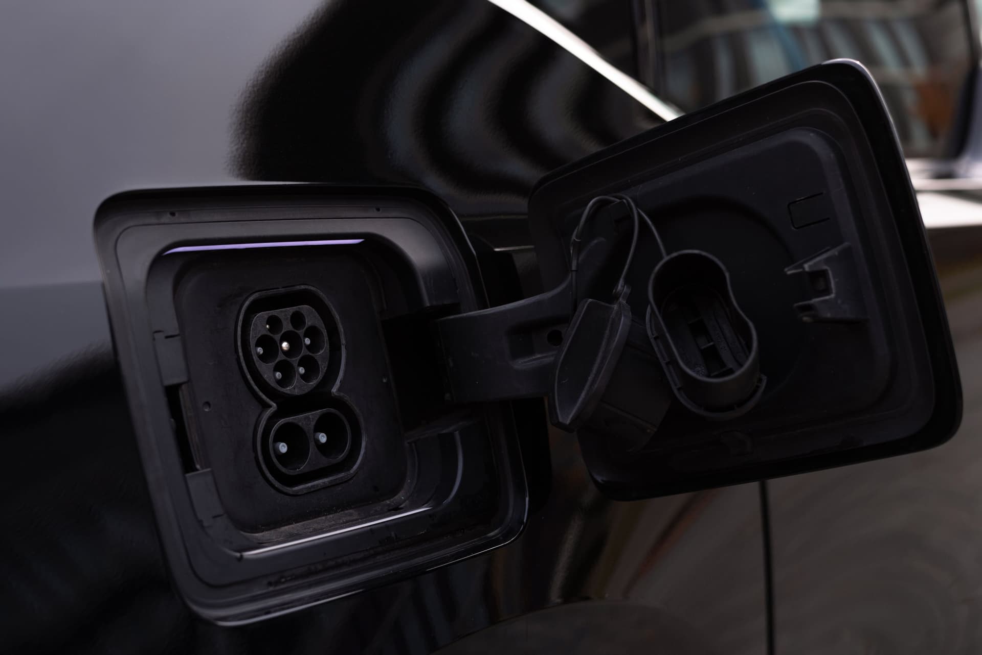 Detalle del conector Tipo 2 enchufado al puerto de carga de un coche eléctrico