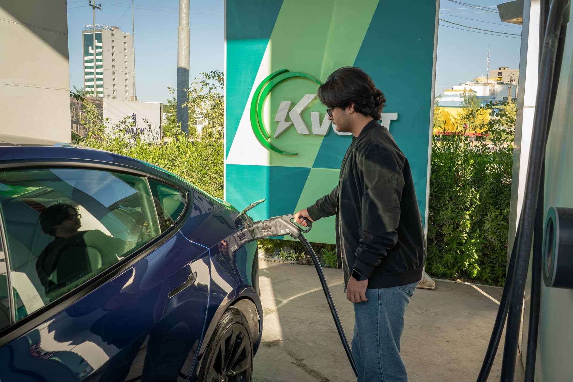 Persona conectando su coche eléctrico a un punto de recarga — Manises